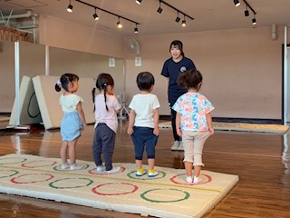 並んで先生のいうことをきちんと聞く年少の子供たち