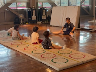 年中・年長さんがマットの上で準備体操をしている様子