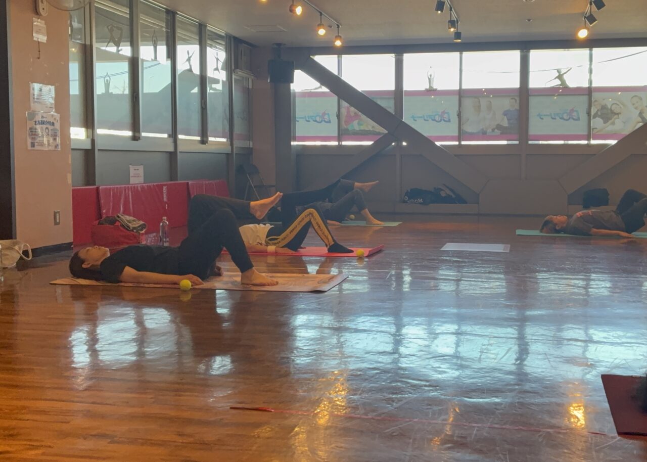 マットの上で足をゆっくり上げながらインナーマッスルを鍛えている様子