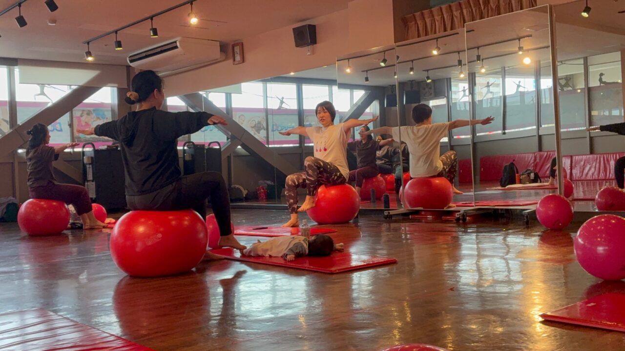 ボールに座りながら、バランスを保ち、体幹を鍛える動き