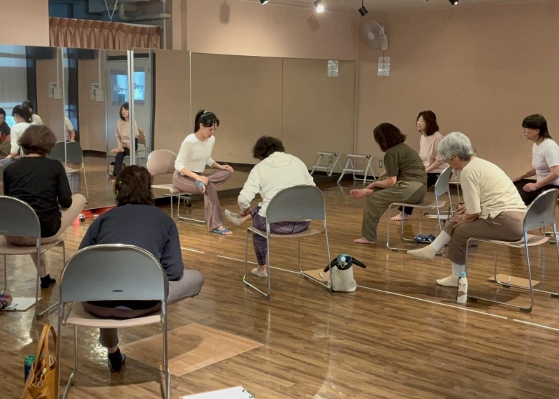 椅子に座って前屈をし、太ももからおしりにかけた部分を伸ばしていきます